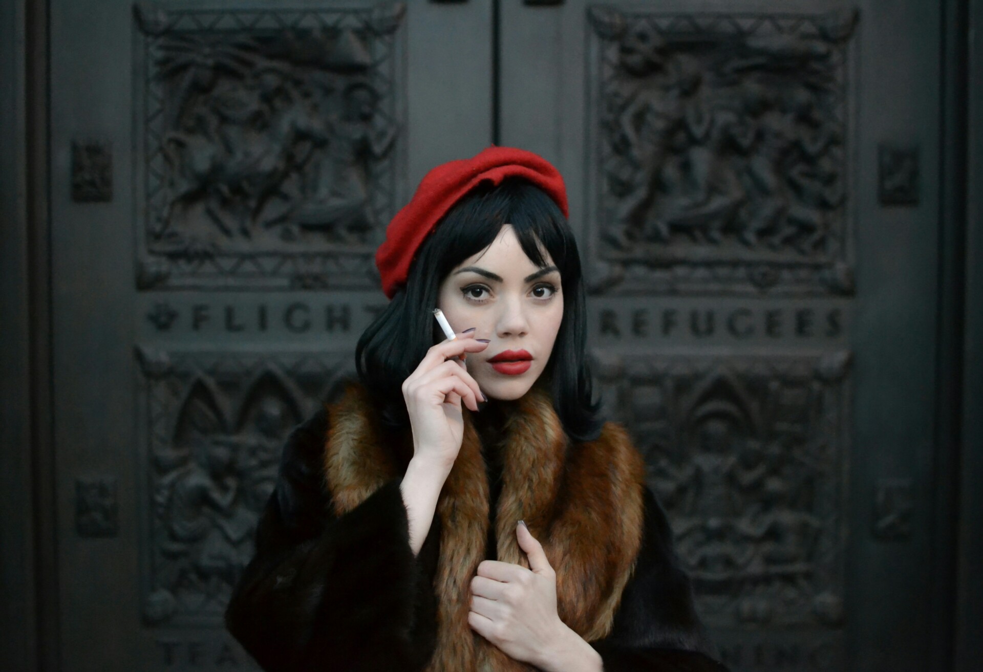 A french women in a red beret holding a cigarette