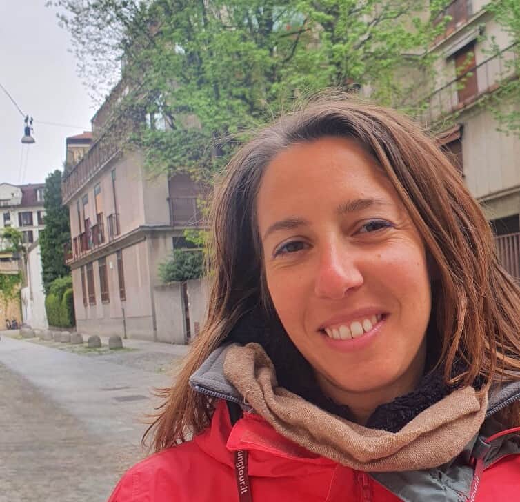 A smiling woman in a red jacket.