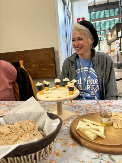 A tour guide smiles while sitting at a table with a special local dessert