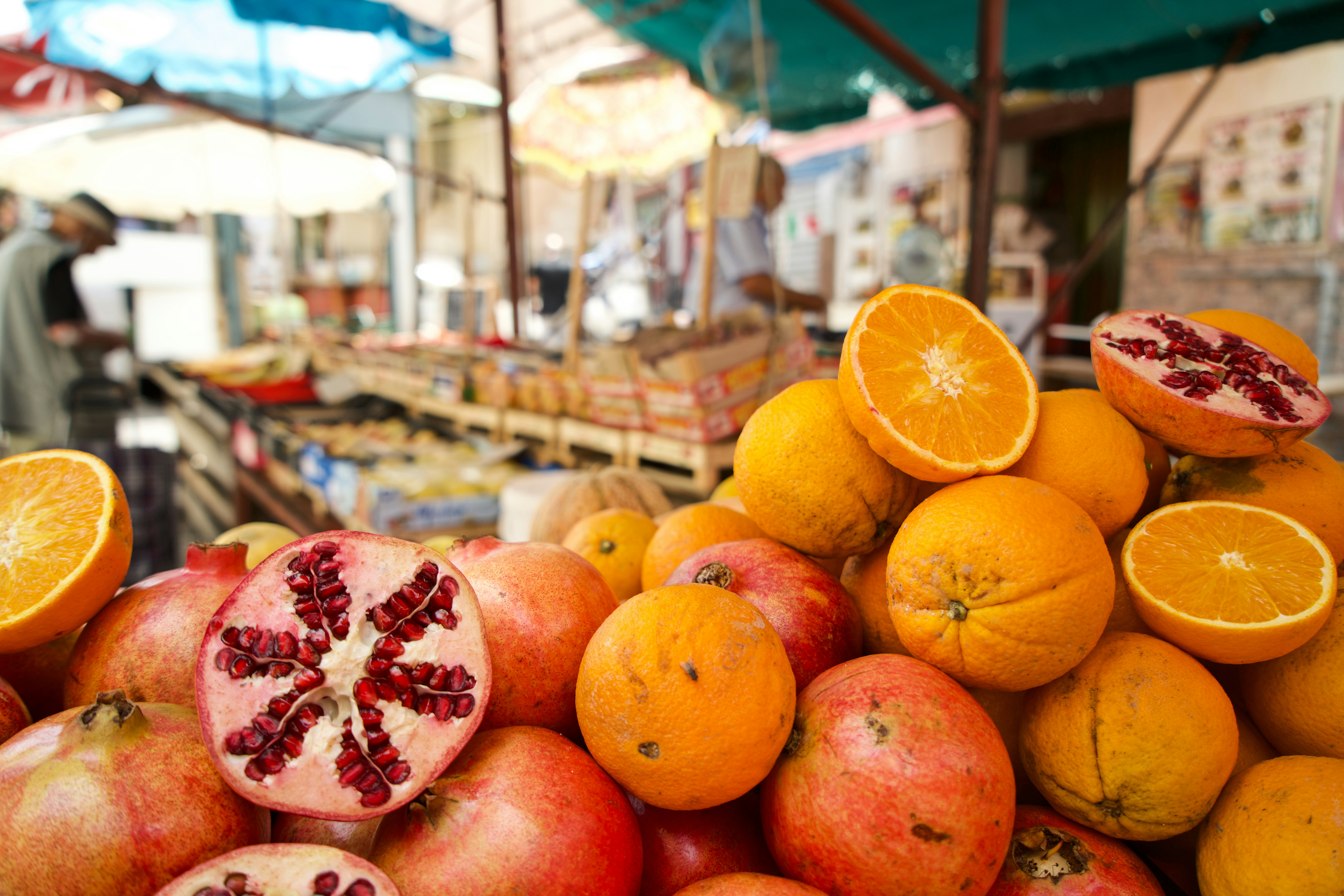 Pomegranates and oranges piled high at a market in Italy