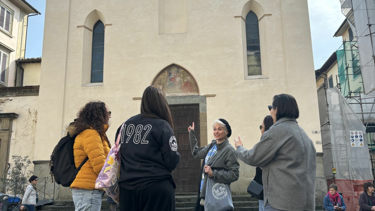 A guide explaining the history of the Sant’ Ambrogio church to a group in Florence, Italy
