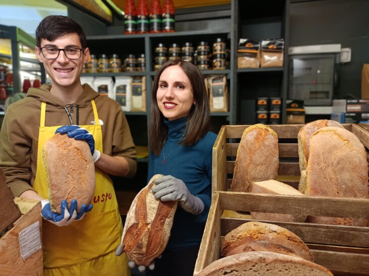 Freshly baked bread being held by two people at a market in Rome, Italy